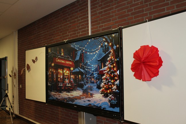 Smartboard zeigt ein verschneites beleuchtetes Café mit einem ebensolchen Weihnachtsbaum vor der Tür