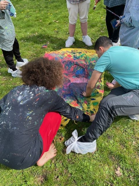 Schüler arbeiten mit Farben auf einer Wiese
